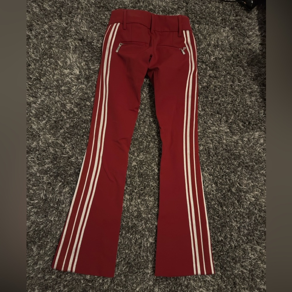 Deep red pants with three white stripes on the back of pants